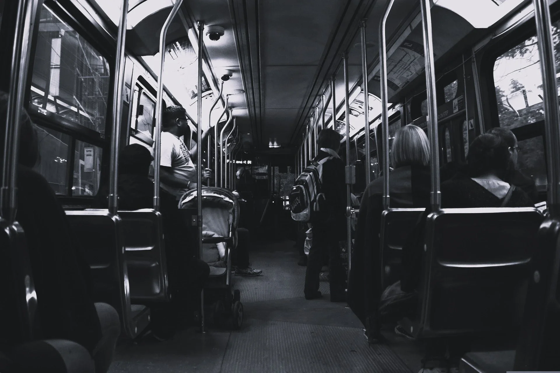 An usual subway train seeing some people in their life, travelling to their destination, the picture is shown as greyscale